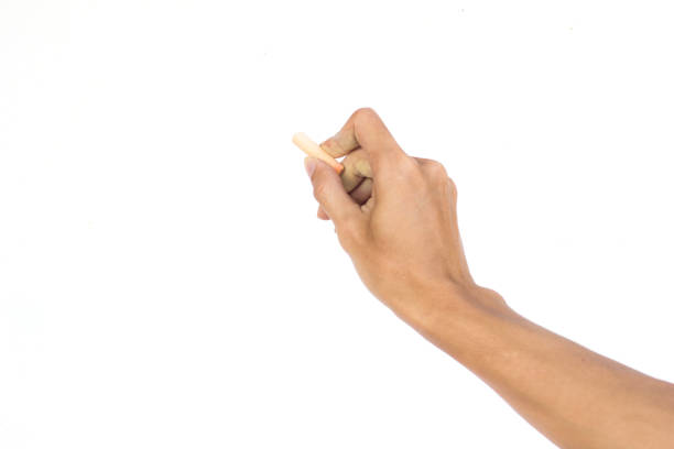 istock Hand holding chalk writing something text on empty space. Isolated on white background. Chalk is used to write text on a blackboard. Chalk made of plaster 872297648