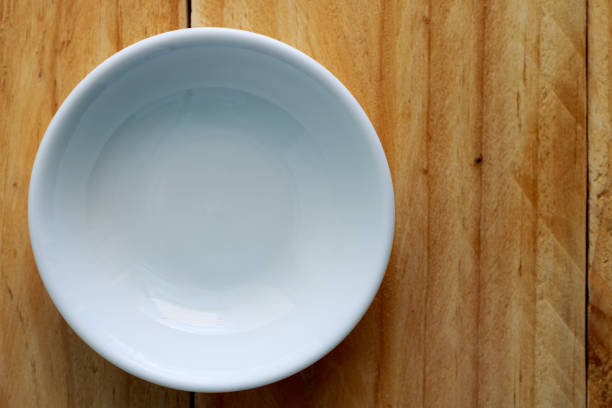 istock white ceramic bowl on wooden table, top view 872297840
