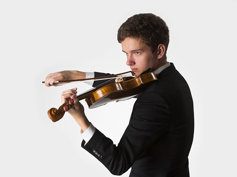 Young musician playing the violin on a white background
