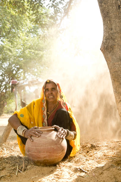 istock Indian woman holding earthen pot 872298596