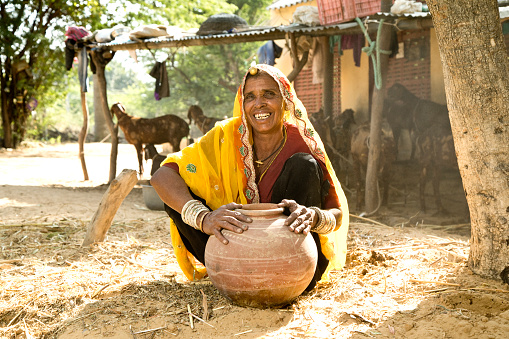 Portrait of Indian woman in sari holding earthen pot