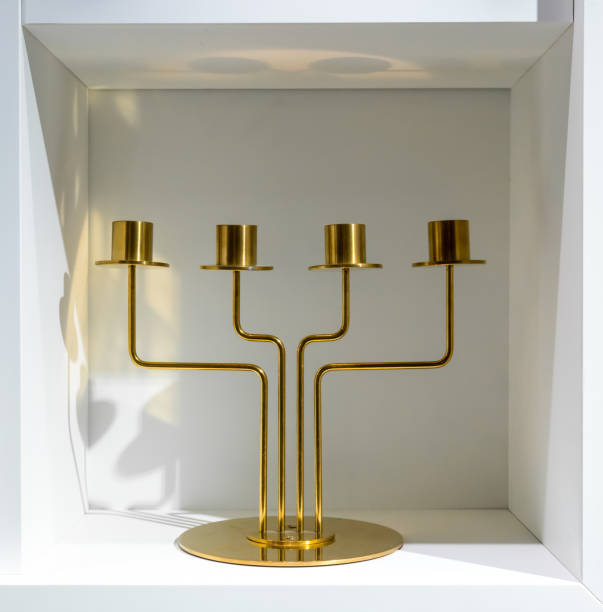 istock Golden candle holder standing in white compartment shelf for decoration. 872301246