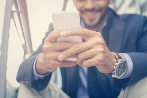 istock Businessman typing on mobile phone. Focus is on hands. 872305242