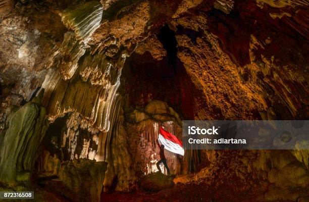 Raising Indonesian Flag In Ancient Cave In Rammangrammang Stock Photo - Download Image Now