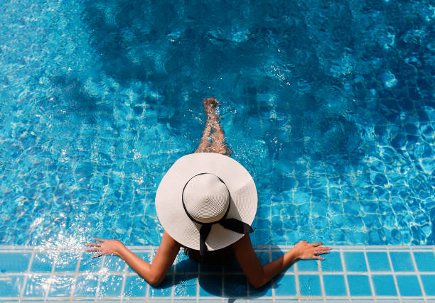 jeune femme asiatique relaxante. - rebord de piscine photos et images de collection