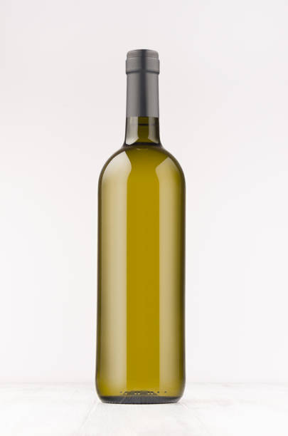 istock Green wine bottle with white wine on white wooden board, mock up, vertical. 872323598