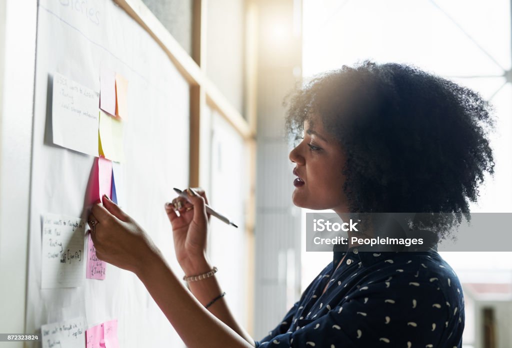 She likes to plan out her day Shot of a young female designer working in her office Aspirations Stock Photo