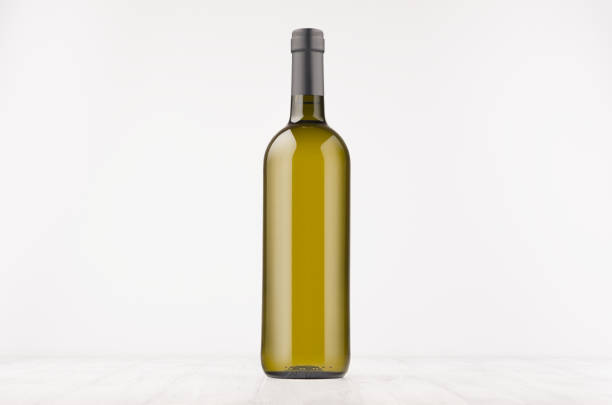 istock Green wine bottle with white wine on white wooden board, mock up. 872324294