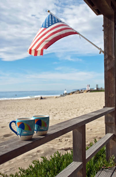With the American flag waving, enjoy cups of coffee on the porch of a favorite beach house in Carpinteria, CA.