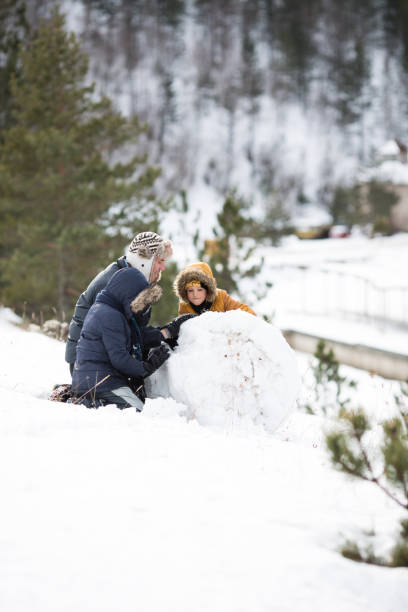 istock Father and sons are playing in the snow 872335610