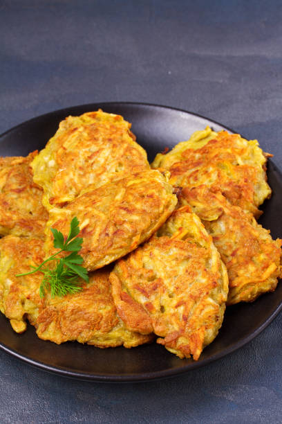 placki ziemniaczane. placki warzywne. latkes na czarnej płycie - hash brown gold food vegetable zdjęcia i obrazy z banku zdjęć