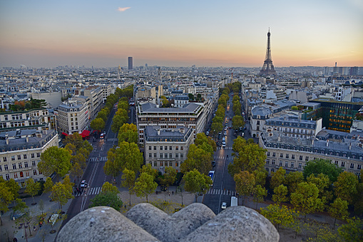 skyline of Paris with Eiffel tower and tour Montparnasse from top of the arch of triumph, place Charles de Gaulle,with a stone part of the Arch in foreground