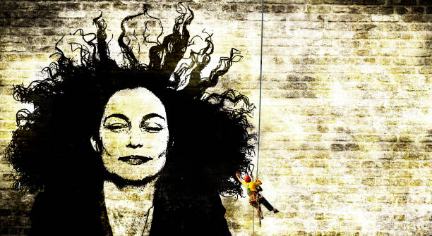 istock A man hangs in a wire while he is painting a beautiful womans face on a wall 872348914