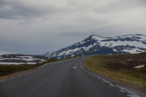 istock On the road with mountains with snow tops 872349732