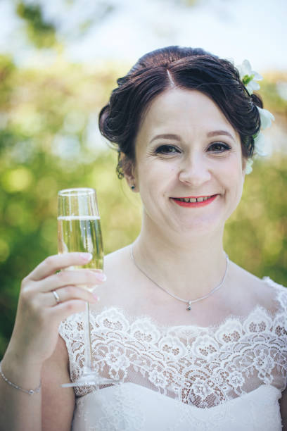 istock Bride on a Wedding Walk with a Glass of Champagne 872353214
