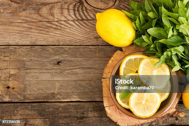 Bundle Of Mint And Slices Of Lemon On Old Wooden Background Copy Space Top View Rustic Style Stock Photo - Download Image Now