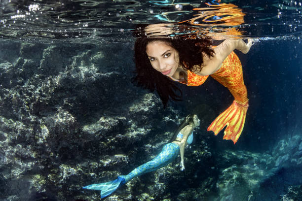 istock Mermaid swimming underwater in the deep blue sea 872356722