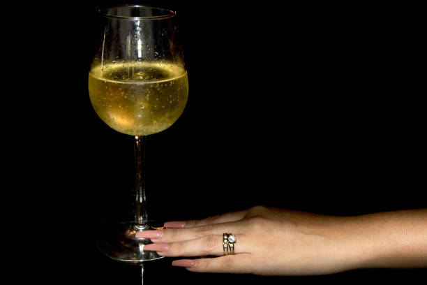istock female hand holding champagne glass 872356770