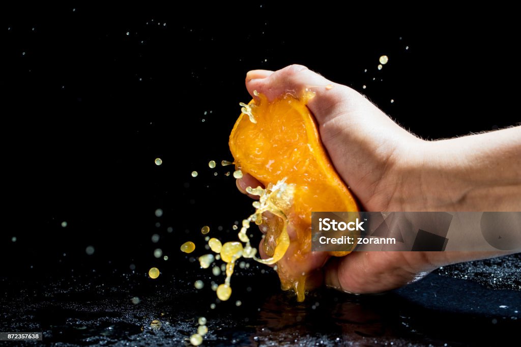 Squeezing orange Woman's hand squeezing orange Squeezing Stock Photo