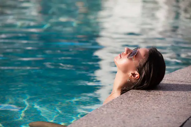 Shot of young woman in swimming pool. Summer vacation.