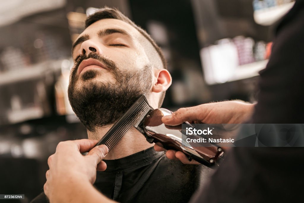 Man krijgt van zijn baard gegarneerd met elektrisch scheerapparaat - Royalty-free Barbierswinkel Stockfoto
