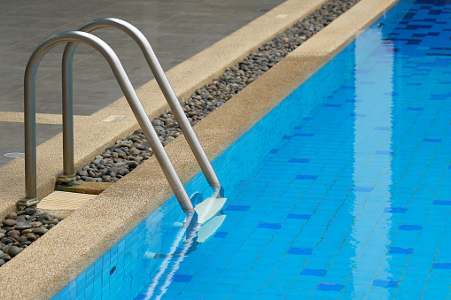 Ladder down the pool, made of stainless steel. For up and down swimming pool to ease the water. with copy space.