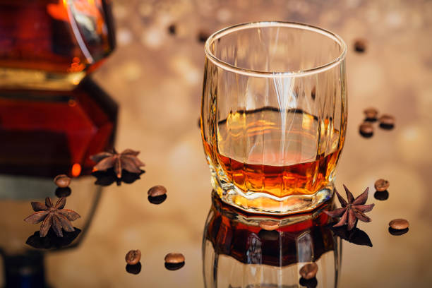 istock Cognac or liqueur, coffee beans and spices on a glass table. 872369610