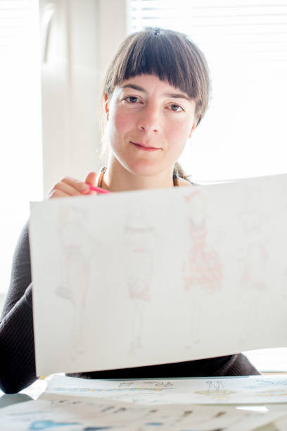 istock Fashion Designer Holding Sketches 872378114
