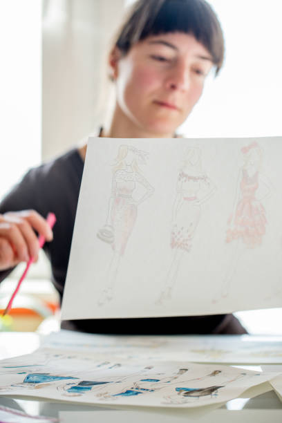 istock Fashion Designer Holding Sketches 872378118