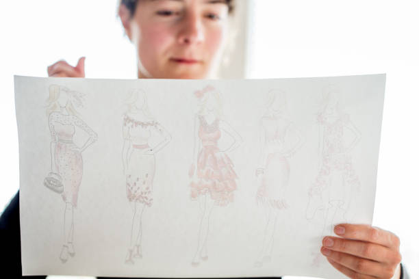 istock Fashion Designer Looking at her Sketches 872378126