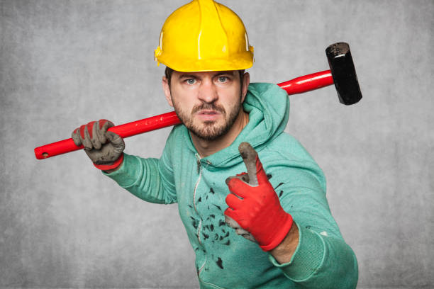 istock A worker with a big hammer threatens his finger 872378764