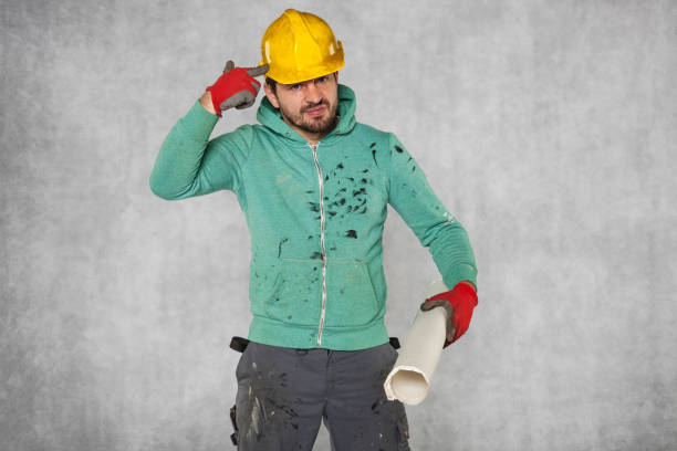 istock crazy idea of a worker, drilling a hole in his head 872378970