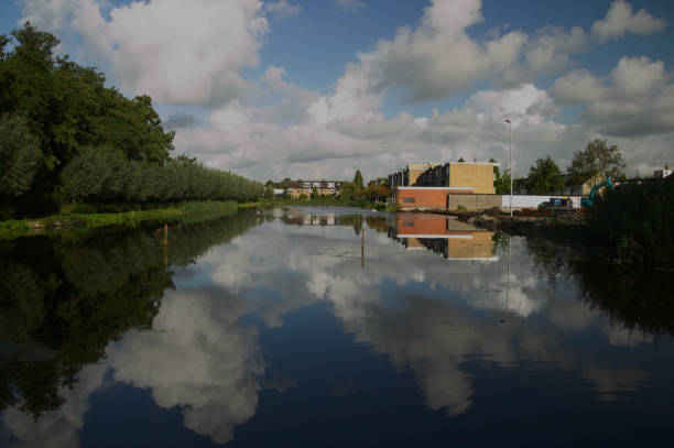 istock Pool in Moordrecht with blue cloud sky reflection while in winter this water is used for ice skating 872379290
