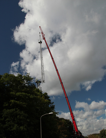 Crane is lifting part of an antenna of the tower for demolishment