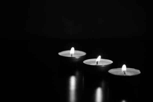Burning candles in the dark. Black and white