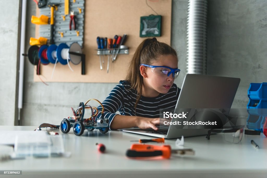 Working on laptop for school assignment Young student searching online for school project Child Stock Photo