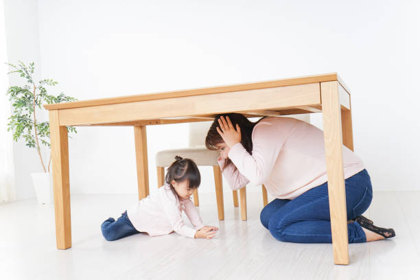 istock A parent and child huddling under a table 872393428