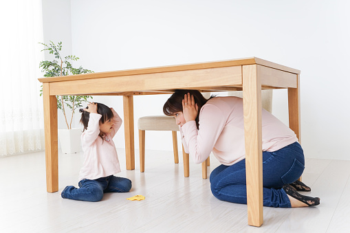 Madre y niño acurrucado debajo de una mesa photo