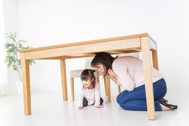 istock A parent and child huddling under a table 872393432