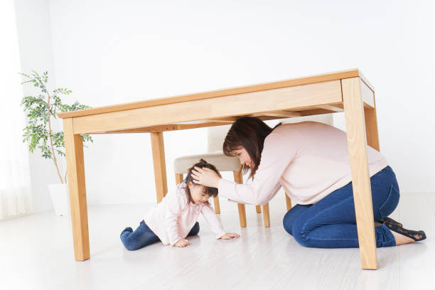 istock A parent and child huddling under a table 872393446