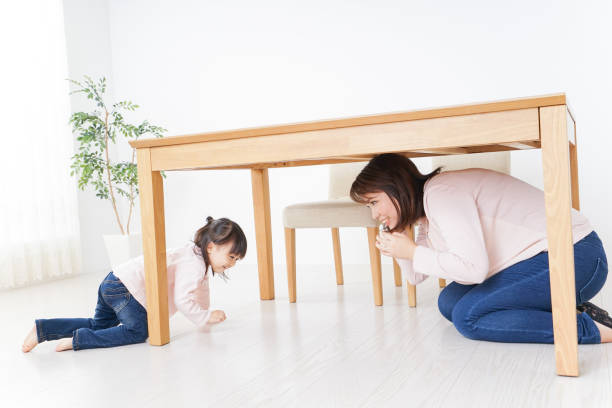 istock A parent and child huddling under a table 872393448
