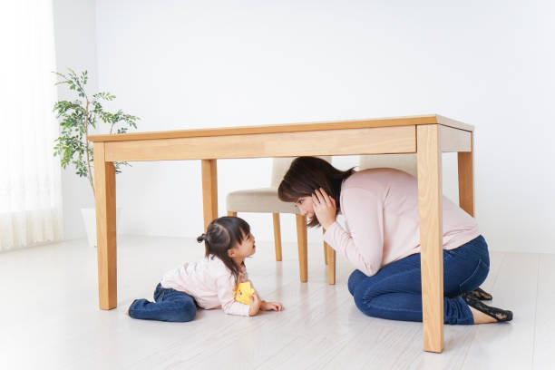 istock A parent and child huddling under a table 872393452