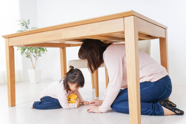 istock A parent and child huddling under a table 872393458