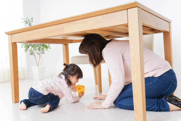 istock A parent and child huddling under a table 872393462