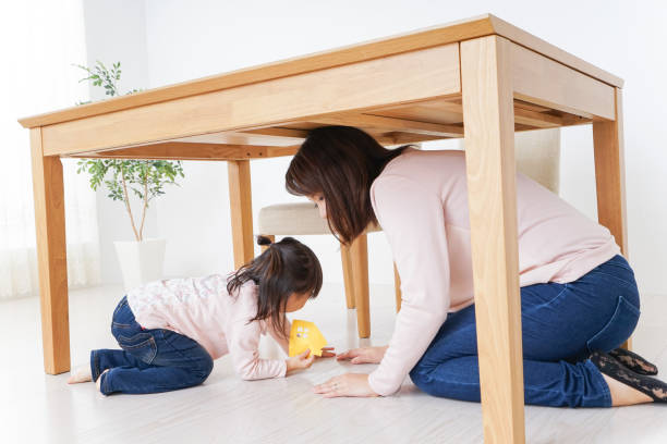 istock A parent and child huddling under a table 872393470