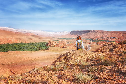 Back view of senior woman standing and taking a photo of Wahabi desert in Oman.