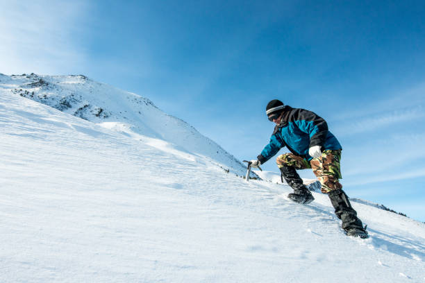 istock climber with an ice ax walks in the snowy mountains 872398836