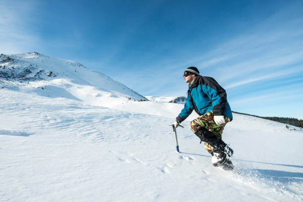 istock climber with an ice ax walks in the snowy mountains 872398842