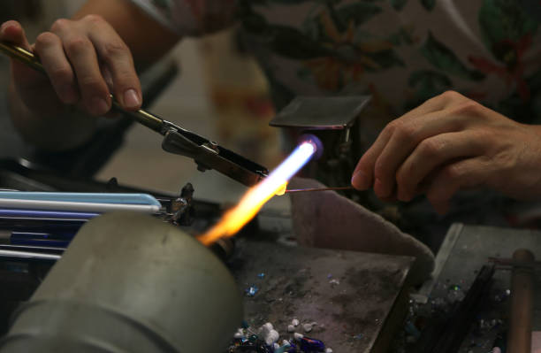 istock Glassmaker while melting and shaping the glass with a very high 872401212