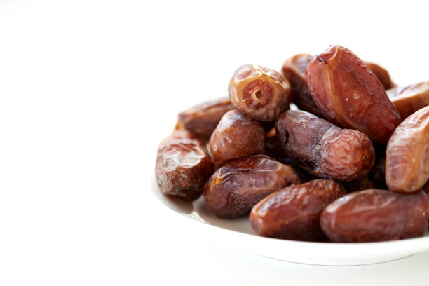 istock Dried Dates Fruits on dish white background 872405728